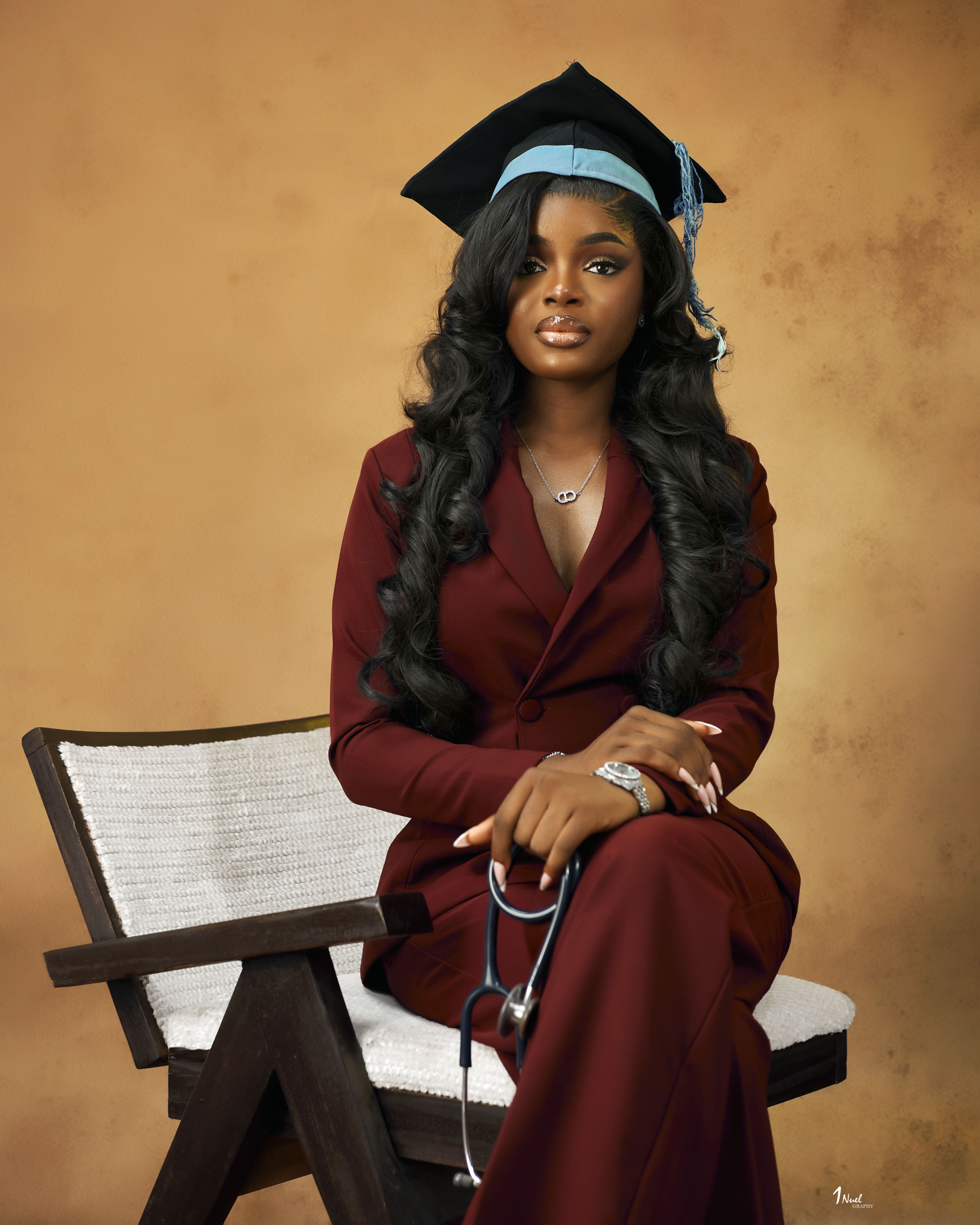 Chisom Nwodo in graduation cap and gown holding a stethoscope